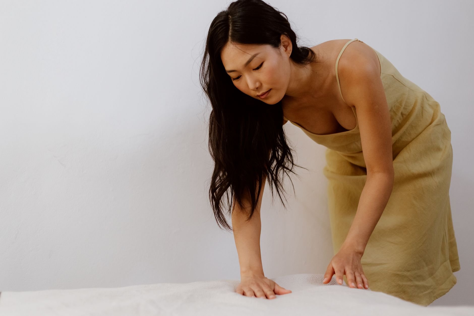 Young woman in a beige dress in a minimalistic room