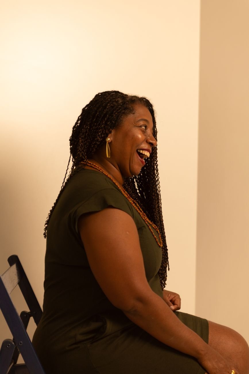 Profile of a smiling woman seated in warm lighting